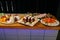 Meal. Festive buffet table for guests. Assortment of cold cuts,canapes on wooden skewers, festive snacks with fruits and