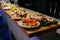 Meal. Festive buffet table for guests. Assortment of cold cuts,canapes on wooden skewers, festive snacks with fruits and