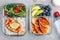 Meal prep containers with salmon, rice, green salad and pancakes, apple, blueberry