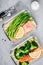 Meal prep lunch box containers with baked salmon fish, rice, green broccoli and asparagus