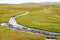 Meandering mountain creek running through tundra landscape