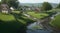 A meandering stream cutting through a village, providing water for the fields.