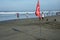 The meaning of the red flag on the beach is the presence of high hazard which means high waves or strong currents.