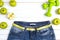 Measure tape with blue womans jeans, green apples and dumbbels o