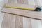 Measuring Laminate Wooden Floor Board with Yellow Measure Tape for Room Reconstruction