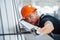 Measuring length of objects. Industrial worker indoors in factory. Young technician with orange hard hat