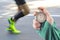 Measuring the running speed of an athlete using a mechanical stopwatch. hand with a stopwatch on the background of the legs of a