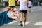 Measuring the running speed of an athlete using a mechanical stopwatch. hand with a stopwatch on the background of the legs of a