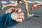 Measuring the running speed of an athlete using a mechanical stopwatch. hand with a stopwatch on the background of the legs of a