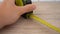 Measuring with yellow tape measure. Hands pull the measuring tape out of tape measure and measure the length. 4k stock