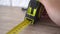 Measuring with yellow tape measure. Hands pull the measuring tape out of tape measure and measure the length. 4k stock