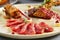 Meat appetizer in beige ceramic plate