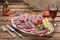 Meat appetizer selection. Salami, prosciutto, bread sticks, olives and sun-dried tomatoes, one glasse red wine over wooden backgro