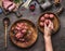 Meat balls making. Female hand puts meat ball in frying pan. Preparation on kitchen table with meat, force meat , meat grinder and