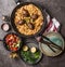 Meat balls with vegetables rice in pan and salad, served on gray stone kitchen table background with plates and cutlery