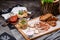 Meat beer snack. Fresh pieces of tasty meat, croutons from dark bread and a cup of broth on a wooden tray