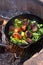 Meat, broccoli and green beans in a cast-iron skillet are fried at the stake. Grilled pieces of meat and juicy greens. Picnic and