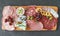 Meat and cheese board with products from Italy - prosciutto, mortadella, felino, bresaola, gorgonzola, parmesan, pate, green