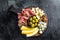 Meat cheese platter antipasti snack with Prosciutto ham, Parmesan, Blue cheese, Melon and Olives on wooden board. Black