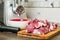 Meat grinder with fresh meat on a cutting board in kitchen interior. Machine for grinding meat into minced meat