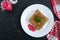 Meat jelly with spicy horseradish on a white plate on a black background. Slavonic traditional cold dish.