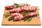 Meat and pepper skewers on a wooden cutting board