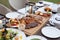 Meat platter served with salad, fries with three choice of sauce on wood block at fine dining table set.