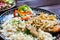 Meat, potatos, rice, onion and salad of vegetable in restaurant on the desk of wood