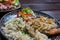 Meat, potatos, rice, onion and salad of vegetable in restaurant on the desk of wood