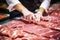 Meat processing plant. A worker sorts cold cuts on a conveyor belt. Arrival of jamon or cold cuts. Production of pork or beef in a