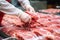 Meat processing plant. A worker sorts cold cuts on a conveyor belt. Arrival of jamon or cold cuts. Production of pork or beef in a