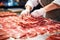 Meat processing plant. A worker sorts cold cuts on a conveyor belt. Arrival of jamon or cold cuts. Production of pork or beef in a