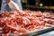 Meat processing plant. A worker sorts cold cuts on a conveyor belt. Arrival of jamon or cold cuts. Production of pork or beef in a