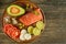 Meat red salmon fish, tomatoes, spices, lemon, green olives on wooden kitchen table.