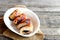 Meat rolls on a plate and on old wooden table with copy space for text