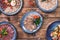 Meat and sausage cuts, garlic, chili peppers, tomatoes and other spices on a wooden brown background