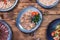 Meat and sausage cuts, garlic, chili peppers, tomatoes and other spices on a wooden brown background