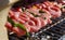 Meat and sausages skewers cooking on a grill