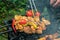 Meat skewered and vegetables on grill grate