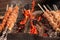 Meat skewers grill. Pork or beef are fried on open fire. Barbecue kitchen party close up image. Kebab or shashlik cooking on spits