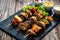 Meat skewers - grilled meat with vegetables on wooden background