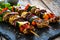 Meat skewers - grilled meat with vegetables on wooden background