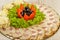 Meat sliced on a mirror dish decorated with verdure.