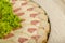 Meat sliced on a mirror dish decorated with verdure.