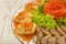 Meat sliced on a mirror dish decorated with verdure.