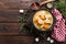 Meat stewed with carrots in sauce and spices in cast iron pan on dark wooden rustic background top view