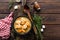 Meat stewed with carrots in sauce and spices in cast iron pan on dark wooden rustic background top view