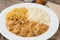 Meat strogonoff with rice and straw potato over wooden table