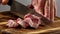 meat tenderloin is cut with a knife. raw meat. preporation process. close-up. pork on a cutting board.