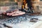 The meat of a traditional Argentine barbecue being roasted on a grill located in the patio of a house.